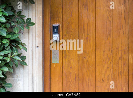 Simple door handle electronic lock with numeric buttons on old wooden door Stock Photo