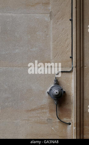 Old retro style, vintage electrical light switch ON OFF with black wires on a old stone wall background Stock Photo