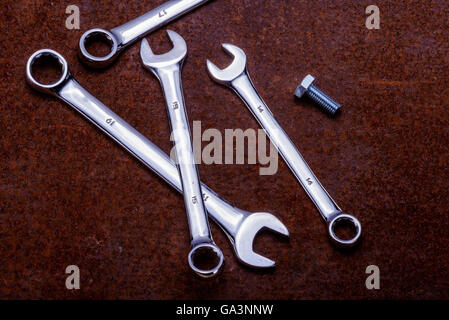 Combination open ended and ring spanners on a rusty sheet metal ground. Stock Photo