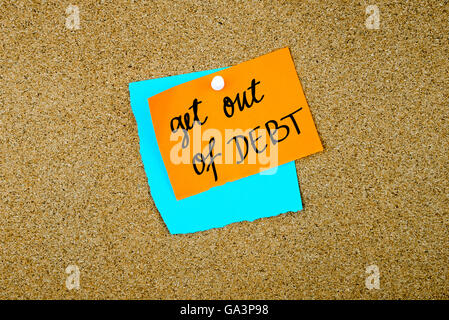 Get Out Of Debt written on paper notes pinned on cork board with white thumb tack, copy space available Stock Photo