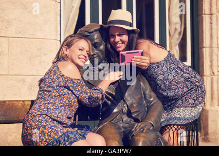 Female friends on holidays, people traveling. Young women in Havana, Cuba, taking selfie picture with camera phone Stock Photo