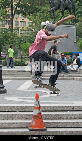 Skateboarders practicing jumps over traffic cones in Union Square Park in New York City