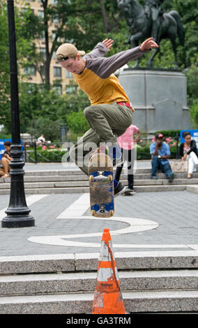 Teenage skateboarders practicing jumps over traffic cones in Union Square Park in New York City