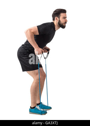 Side view of young fit athlete with resistance bands doing back exercise. Full body length portrait isolated over white Stock Photo