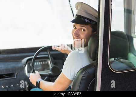 Smiling bus driver driving a bus Stock Photo