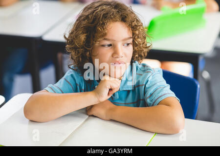 Thoughtful boy looking away while studying Stock Photo
