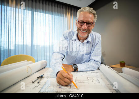 Architect working on blueprint at desk Stock Photo