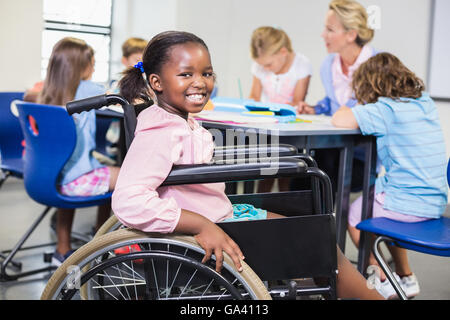 Disabled schoolgirl smiling in classroom Stock Photo