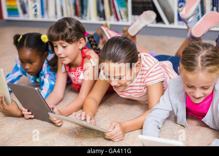 Kids using digital tablet in library Stock Photo