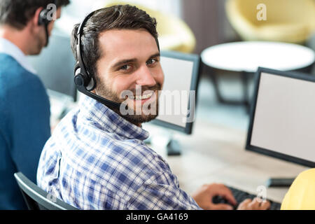 Young man working on computer with headset Stock Photo