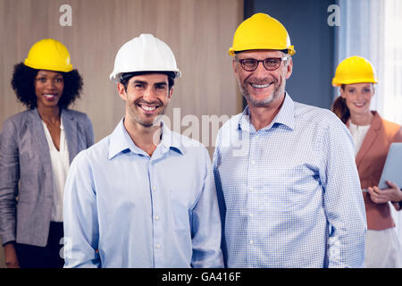 Team of smiling architects standing in office Stock Photo
