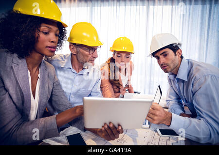Architects discussing over digital tablet in office Stock Photo
