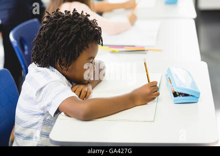 School boy doing homework in classroom Stock Photo