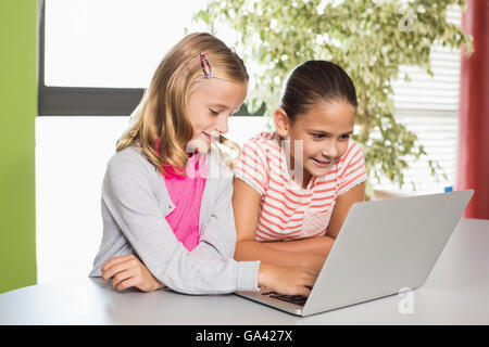 Kids using laptop in library Stock Photo