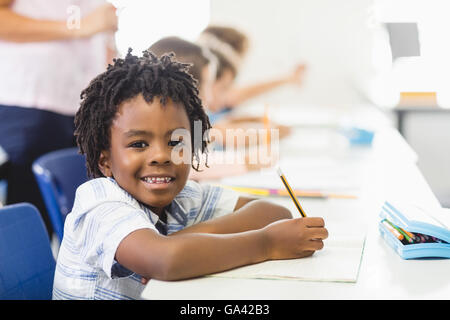School boy doing homework in classroom Stock Photo