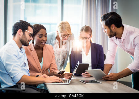 Business people interacting using laptop, mobile phone and digital tablet Stock Photo