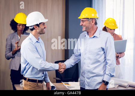 Two architects shaking hands in office Stock Photo