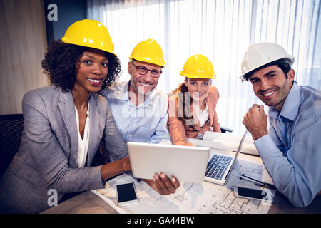 Smiling architects discussing over digital tablet in office Stock Photo
