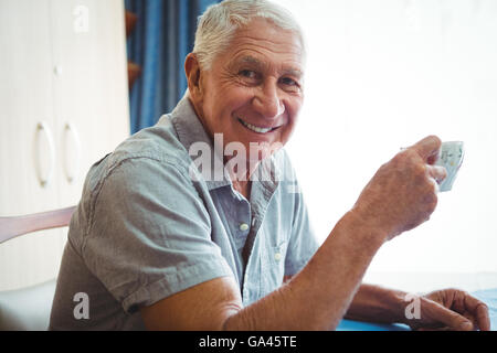 Retired smiling man holding a cup of tea Stock Photo