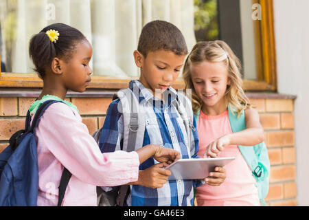 Smiling kids using a  and digital tablet Stock Photo