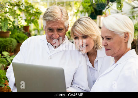 Scientists smiling while discussing over laptop Stock Photo