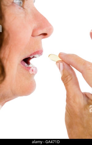 Cropped image of woman taking pill