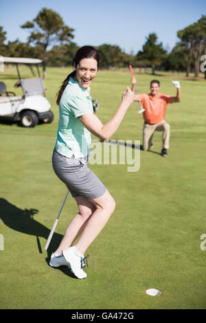 Portrait of happy golfer woman clenching fist Stock Photo