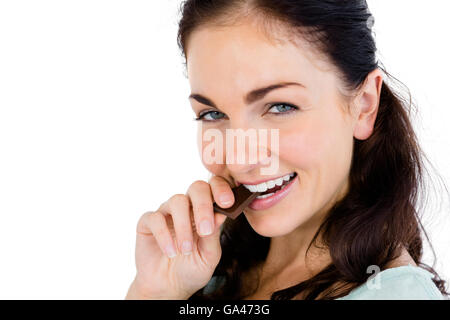 Close-up portrait of smiling woman eating chocolate bar Stock Photo