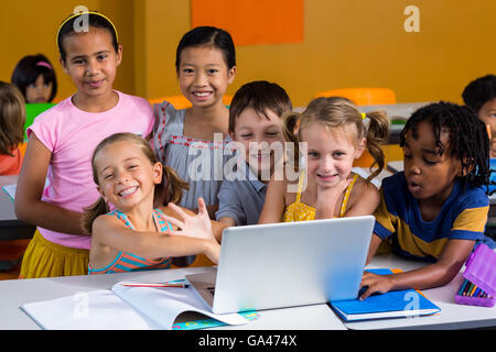 Smiling multi ethnic children using laptop Stock Photo
