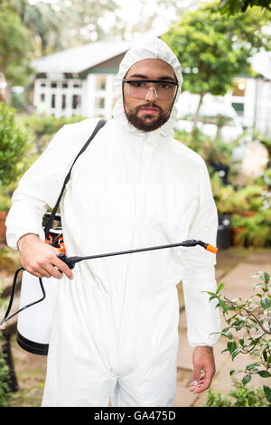 Portrait of male scientist spraying pesticides Stock Photo