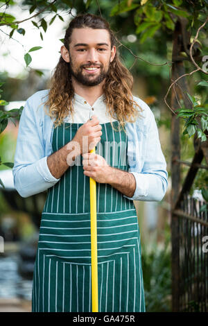 Portrait of happy gardener holding work tool at garden Stock Photo