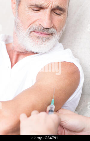 Senior man in pain looking on being vaccinated Stock Photo