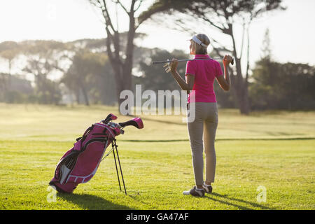 Rear view of mature woman holding golf club Stock Photo