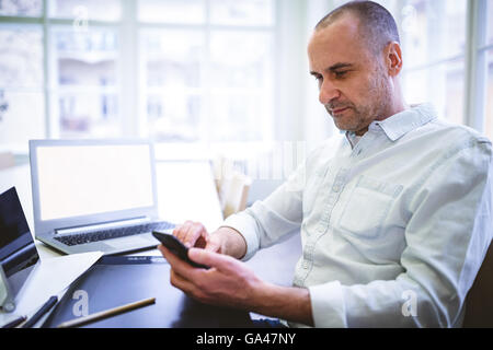 Businessman using mobile phone at desk