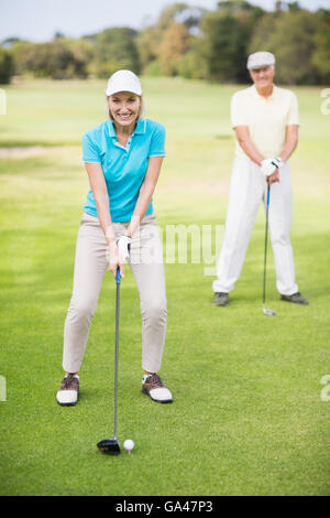 Portrait Of A Mature Man Holding A Golf Club And Standing With A Mature 