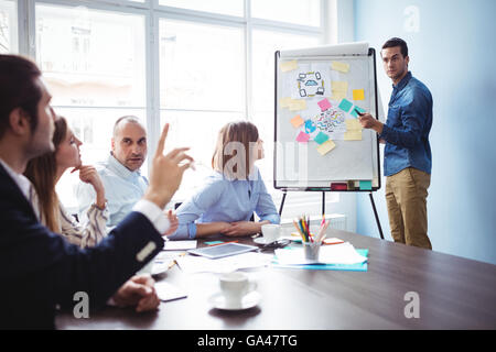 Speaker calling colleague with hand raised during meeting Stock Photo