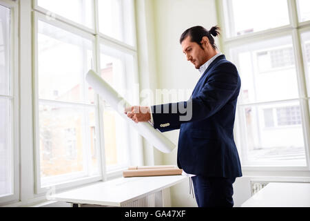 Confident architect holding blueprint Stock Photo