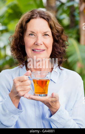 Smilng mature woman drinking herbal tea Stock Photo