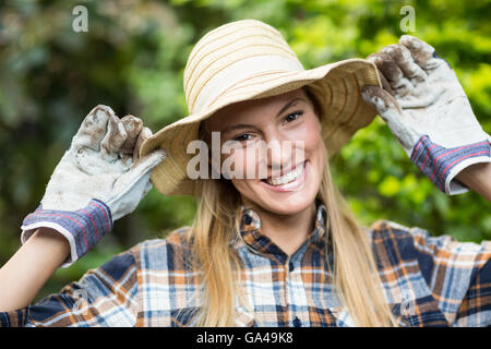 Happy female gardener wearing hat Stock Photo