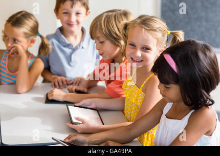 Smiling children using digital tablets Stock Photo