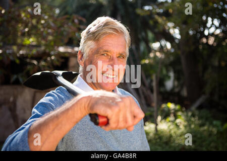 Portrait of confident gardener carrying shovel on shoulder at garden Stock Photo