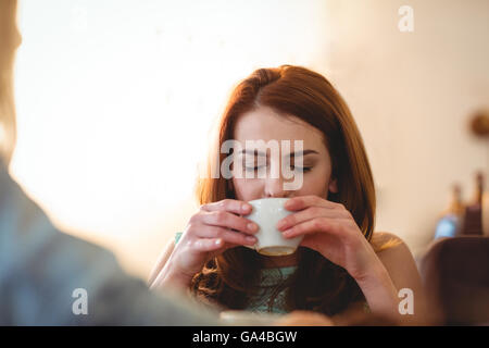 Beautiful woman sipping coffee with friend at cafe Stock Photo