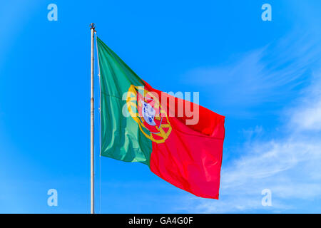 Portuguese flag waving in the wind against a blue sky background at Silves castle, Portuga Stock Photo