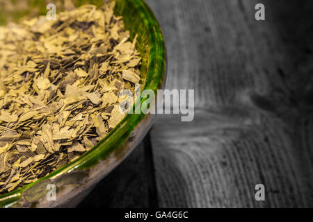 Dried green tea leaves in a green  glass jar Stock Photo