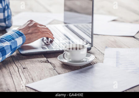 Man in casual clothes using a laptop computer in office Stock Photo