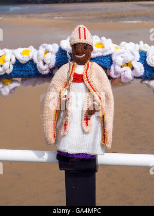 Yarn Bombing decorating public place with knitted objects here Yorkshire Archbishop John Sentamu on Saltburn Pier handrail Stock Photo