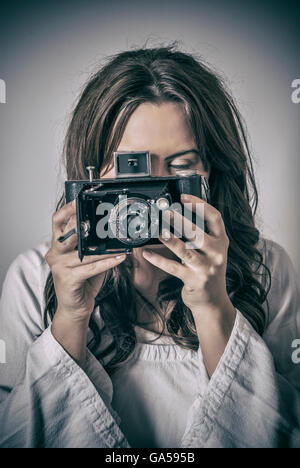 Close up of a woman holding a vintage camera Stock Photo