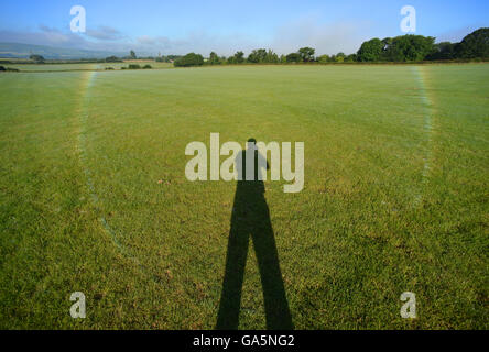 Sussex, UK. July 4th 2016. Dew covered cobwebs on a turf field in Ripe, East Sussex, refract the early morning light creating an unusual inverted rainbow. Credit: Peter Cripps/Alamy Live News Stock Photo