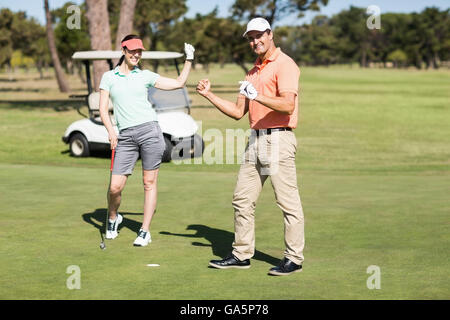 Full length portrait of golfer couple celebrating success Stock Photo