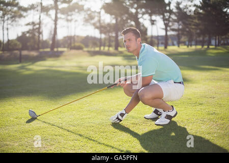 Full length of golfer man placing golf ball on tee Stock Photo